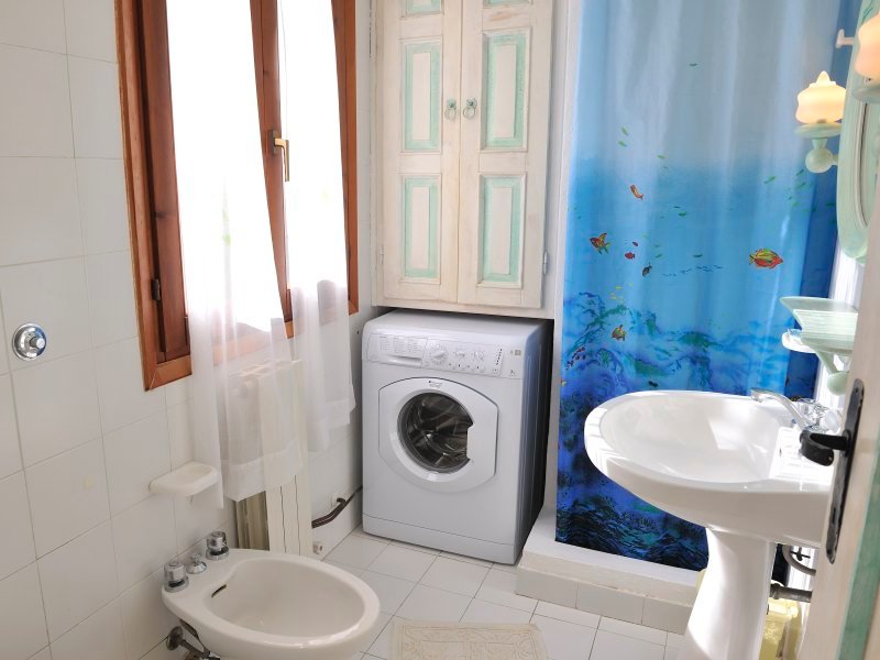Badezimmer mit Dusche und Waschmaschine Badezimmer mit Dusche und Waschmaschine