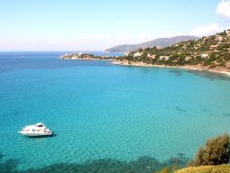 Bucht von Torre delle Stelle, auf dem durchsichtigen Meer schwimmt eine Motorjacht Bucht von Torre delle Stelle, auf dem durchsichtigen Meer schwimmt eine Motorjacht