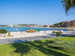 Stadtstrand mit Rasen und weißem Sand beim Hafen von Golfo Aranci Stadtstrand mit Rasen und weißem Sand beim Hafen von Golfo Aranci