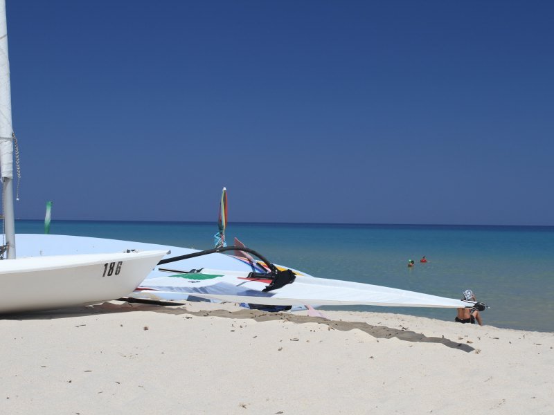 Surfbrett am Strand von Cala Sinzias