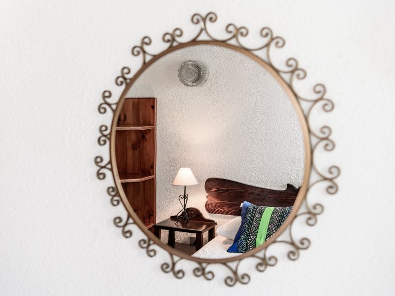 Ein handgefertigter Spiegel dekoriert das Schlafzimmer