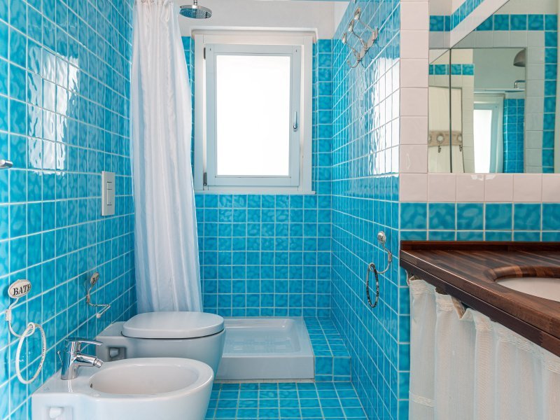 Badezimmer 2 mit Fenster und Fliesen in türkis blau