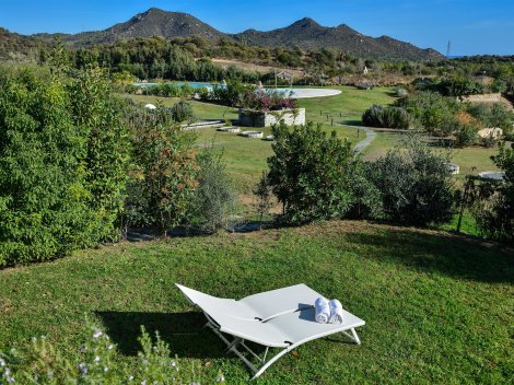 Garten mit Sonnenliegen und Blick auf den Pool