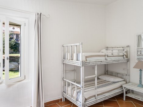 Schlafzimmer 2 mit einem Stockbett und einem Einzelbett und Fenster zum Garten