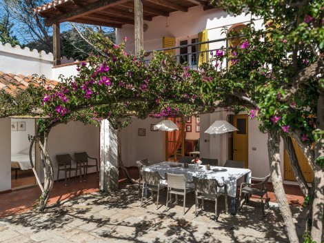 Innenhof mit Esstisch im Freien und romantischem Bougainville