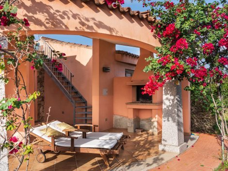 Gemauerter Barbecue und Sonnenliegen.