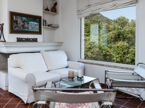 Elegantes Wohnzimmer mit Panoramafenster auf die Felslandschaft im Garten