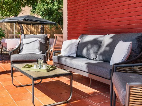 Überdachte Terrasse mit Sofa- und gemütichen Sesseln